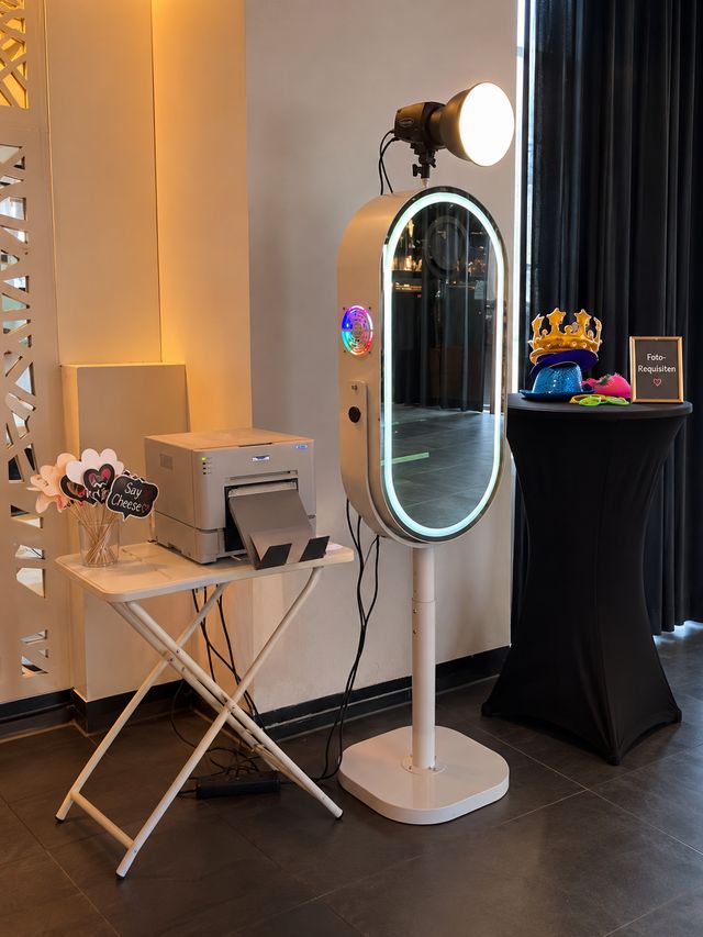 Spiegel-Fotobox mit Leuchtrahmen, Drucker und Tisch mit Foto-Requisiten