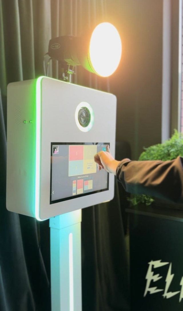 Gast tippt auf den Touchscreen der Fotobox und wählt ein Layout